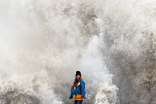 A young woman watches waves crash over the seafront in the Black Sea resort of Sochi, Russia during a storm on December 1, 2021. (Photo by Dmitry Feoktistov/TASS)