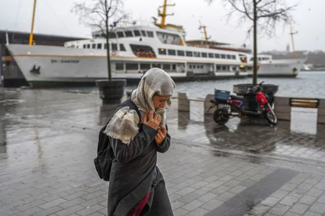 A woman walks under a heavy rain during a stormy day in Istanbul, Turkey, Monday, November 29, 2021. A powerful storm pounded Istanbul and other parts of Turkey on Monday, killing at least four people and causing havoc in the city of 15 million people, reports said. (Photo by AP Photo/Stringer)