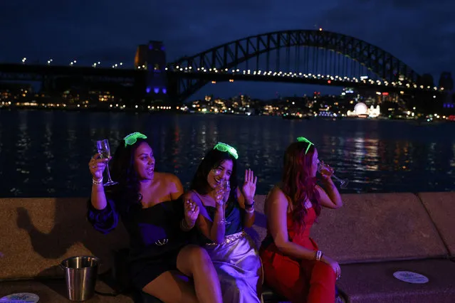 Women celebrate New Year's Eve at the Sydney Harbour waterfront amidst tightened COVID-19 prevention regulations in Sydney, Australia, December 31, 2020. (Photo by Loren Elliott/Reuters)