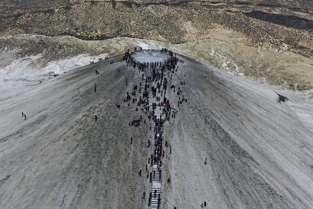 In this aerial photo taken from a drone, Hindu devotees climb stairs to reach on top of a mud volcano to start Hindu pilgrims religious' rituals for an annual festival in an ancient cave temple of Hinglaj Mata in Hinglaj in Lasbela district in Pakistan's southwestern Baluchistan province, Friday, April 26, 2024. More than 100,000 Hindus are expected to climb mud volcanoes and steep rocks in southwestern Pakistan as part of a three-day pilgrimage to one of the faith's holiest sites. (Photo by Mohammad Farooq/AP Photo)