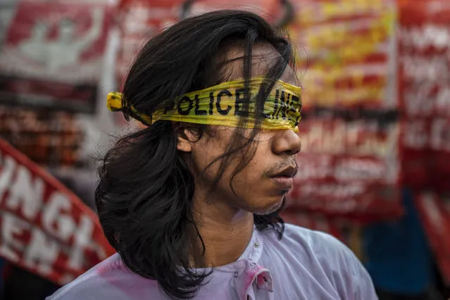 A Filipino protester depicting “lady justice” wears police tape over his eyes as he marches through the street leading to the Philippine congress where President Rodrigo Duterte will deliver his State of the Nation Address on July 22, 2019 in Manila, Philippines. Filipino protesters rallied on the streets on Monday during President Rodrigo Duterte's fourth State of the Nation Address on Monday to outline his economic priorities while global human rights activists continue to place pressure on his on-going war on drugs. (Photo by Ezra Acayan/Getty Images)