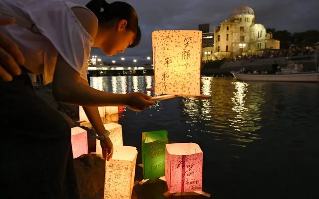 A girl floats a lantern on Motoyasu River in Hiroshima, western Japan, on August 6, 2019, in memory of victims of the atomic bombing of the city, on its 74th anniversary. (Photo by Kyodo News via Getty Images)