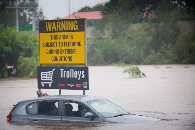 Submerged cars sit in a flooded carpark in Toombul, in Queensland, Australia on March 30, 2017. Torrential rain hampered relief efforts after powerful cyclone Debbie wreaked havoc in northeast Australia, with floods sparking emergency rescues as fed-up tourists began evacuating from resort islands. (Photo by Patrick Hamilton/AFP Photo)