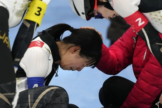 Nana Takagi of Team Japan is comforted by teammates after falling during the speedskating women's team pursuit finals at the 2022 Winter Olympics, Tuesday, February 15, 2022, in Beijing. (Photo by Ashley Landis/AP Photo)