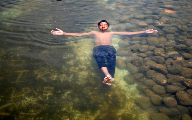 A boy cools off during the heat wave at the Suhrawardy Udyan water reserve in Dhaka, Bangladesh, 22 April 2024. According to the Bangladesh Meteorological Department (BMD) the duration of heat wave has been extended by three more days, Meteorological office issued a new waring on 22 April for next 72 hours. (Photo by Monirul Alam/EPA/EFE)