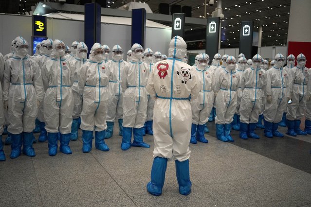 Olympic workers in protective clothing have a meeting at Beijing Capital International Airport after the 2022 Winter Olympics, Monday, February 21, 2022, in Beijing, China. (Photo by Alessandra Tarantino/AP Photo)