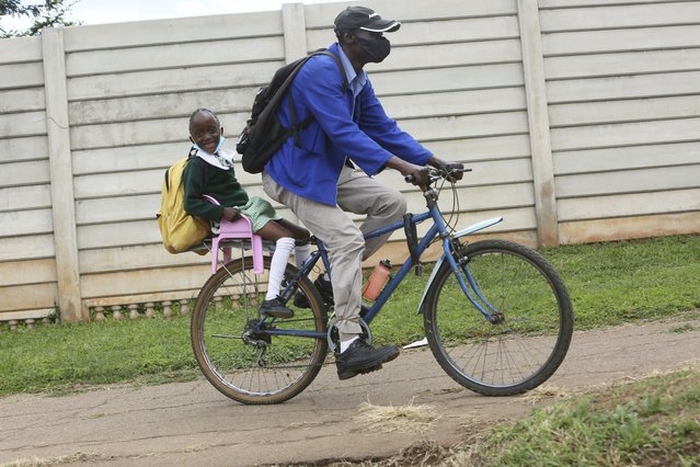 A parent transports her child  to school using a bicycle in Harare, Wednesday, February 9, 2022. A pay strike by teachers has paralyzed learning at many Zimbabwean schools, which belatedly opened on Monday after a pandemic-induced prolonged closure. (Photo by Tsvangirayi Mukwazhi/AP Photo)