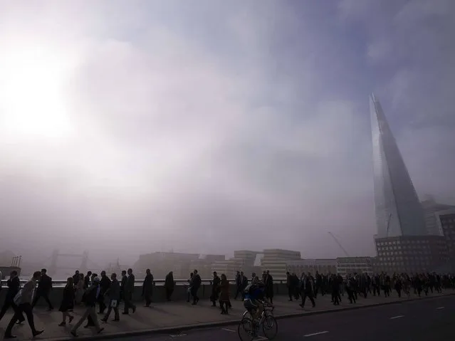 Commuters walk across London Bridge in the early morning fog in central London, on April 30, 2014, as a strike by underground train staff affected a second morning's rush-hour. The strike action was called by the RMT union in protest at plans to close all ticket offices across the network, which it says will jeopardise hundreds of jobs and safety standards. (Photo by Carl Court/AFP Photo)