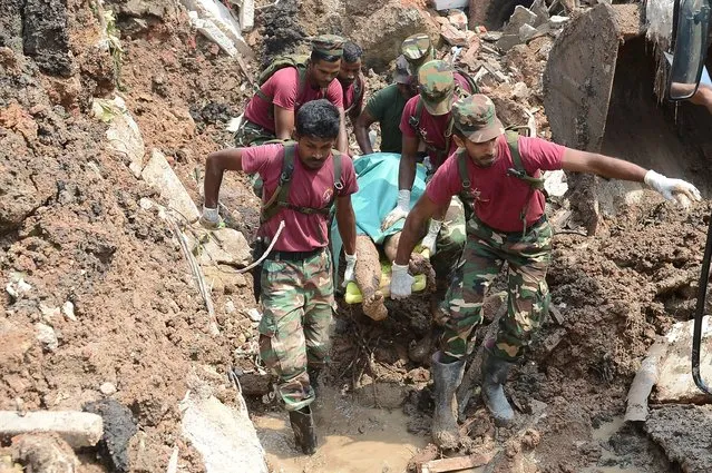 Sri Lankan military rescue workers recover the body of a man in the rescue operations at the site of a collapsed garbage dump in Colombo on April 15, 2017. The death toll from a collapsed garbage mountain in Sri Lanka' s capital rose to 11 April 15 as rescuers searched for survivors after 145 homes were destroyed, officials said. (Photo by Lakruwan Wanniarachchi/AFP Photo)