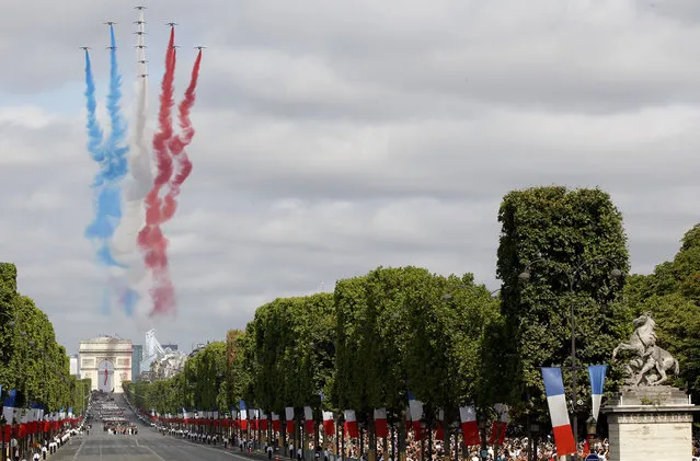 Jets for the Patrouille de France fly over the Champs Elysees avenue during the traditional Bastille Day parade in Paris, France, Tuesday, July 14, 2015. French anti-terrorist forces join the traditional military parade celebrating Bastille Day, as the country's leadership tries to show its muscle against extremists abroad and at home. Mexico's president is the guest of honor at this year's event marking France's biggest holiday. (Photo by Michel Euler/AP Photo)
