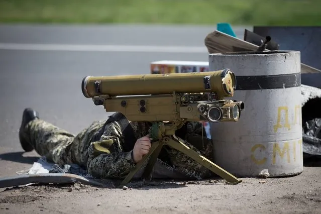 A pro-Russian militant takes his position with an anti-tank rocket launcher preparing to fight against Ukrainian government troops at a checkpoint blocking the major highway which links Kharkiv, outside Slovyansk, eastern Ukraine, Friday, May 16, 2014. (Photo by Alexander Zemlianichenko/AP Photo)