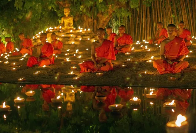 Thai Buddhist monks meditate with candle lighting during the religious ceremony to mark Vesak Day or Visakha Bucha at Wat Pan Tao in Chiang Mai province, northern Thailand, 20 May 2016. Vesak Day or Visakha Bucha, one of the holiest days in Buddhism to commemorating the birth, enlightenment and the death of Buddha. (Photo by Pongmanat Tasiri/EPA)