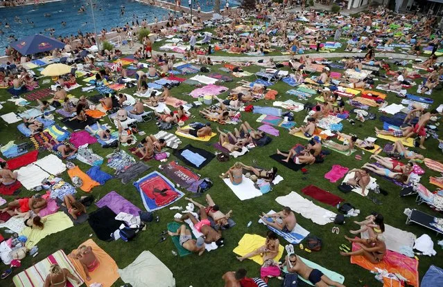 People relax at the public swimming pool of Schoenbrunner Bad on a sunny day in Vienna, Austria, July 19, 2015. Temperatures rose up to more than 37 degrees Celsius (98 Fahrenheit) in parts of Austria this weekend, Austria's national weather service agency ZAMG reported. (Photo by Leonhard Foeger/Reuters)