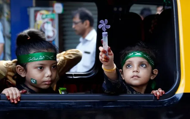 Indian Muslim children look from inside a cab as they participate in a procession to celebrate Prophet Muhammad's birthday in Mumbai, Sunday, November 10, 2019. (Photo by Rajanish Kakade/AP Photo)