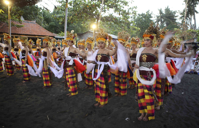 Balinese dancers wearing traditional outfits perform during 'usaba manggung', a Hindu ceremony related to agriculture to honor goddess Sri, at Bugbug village in Karangasem, Bali, Indonesia, Thursday, July 18, 2024. (Photo by Firdia Lisnawati/AP Photo)