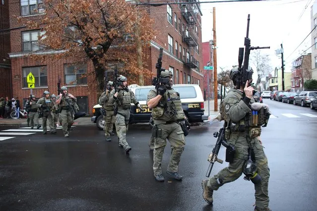 Police officers arrive to the scene where an active shooting was taking place in Jersey City, New Jersey on December 10, 2019. One officer was shot when two gunmen with a long rifle opened fire in Jersey City, New Jersey, on the afternoon of December 10, 2019 , according to two officials. Two suspects were barricaded in a convenience store, the officials said. One officer was being taken to a nearby hospital. (Photo by Kena Betancur/AFP Photo)