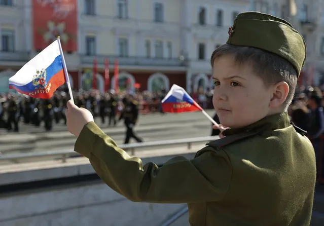 A boy wearing the Red Army styled uniform watches a parade on Victory Day, which marks the 77th anniversary of the victory over Nazi Germany in World War Two, in Vladivostok, Russia on May 9, 2022. (Photo by Tatiana Meel/Reuters)