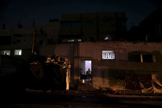 Palestinians sit inside their house, lit by lamps powered by  a battery, during power cut at Shatti (beach) refugee camp in Gaza City July 23, 2015. (Photo by Mohammed Salem/Reuters)