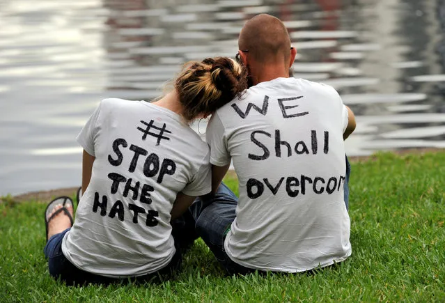 Orlando residents Arissa Suarez (L) and Malcom Crawson attend a vigil at Lake Eola Park for victims of a mass shooting at a gay nightclub in Orlando, Florida, U.S June 12, 2016. (Photo by Steve Nesius/Reuters)