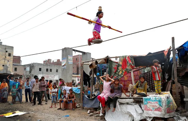 A girl performs circus tricks in a slum area of Ghaziabad, on the outskirts of Delhi, India June 28, 2017. (Photo by Cathal McNaughton/Reuters)