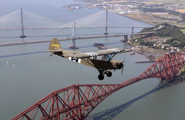 Jim McTaggart takes his 1940 Piper Cub for a practice flight over the Forth rail bridge, the Forth road bridge and the new Queensferry crossing ahead of the aircraft’s appearance at Scotland’s National Airshow in Queensferry, Scotland on July 19, 2017. (Photo by Andrew Milligan/PA Wire)