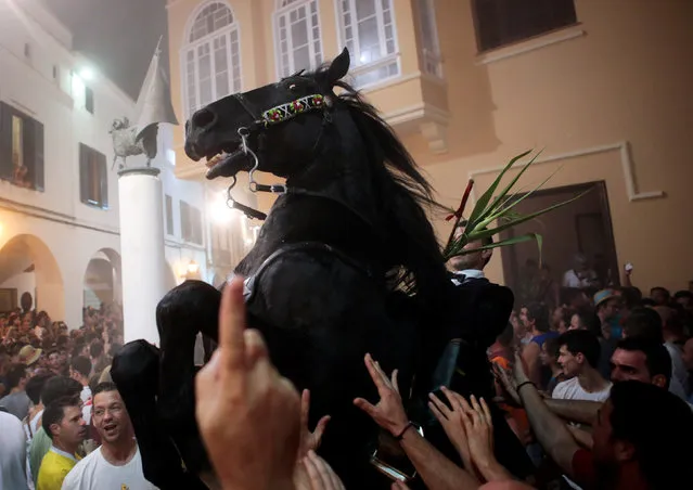 A rider rears up on his horse while surrounded by a cheering crowd during the traditional Fiesta of Sant Joan (Saint John) in downtown Ciutadella, on the island of Menorca, Spain June 23, 2016. (Photo by Enrique Calvo/Reuters)