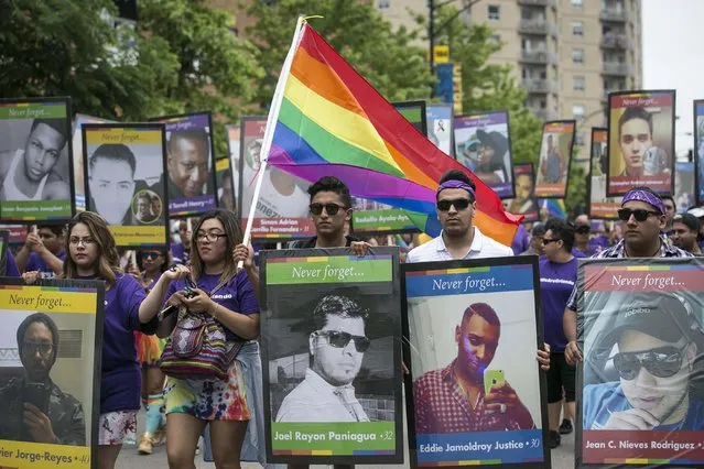 Participants in the 47th annual Chicago Pride Parade carry pictures of the victims killed in the Pulse nightclub shooting as a tribute on Sunday, June 26, 2016. (Photo by Ashlee Rezin/Chicago Sun-Times via AP Photo)