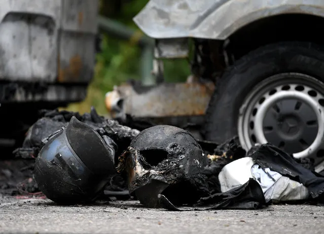 Remains of helmets are seen in front of vehicles of the federal police, parked in front of a hotel where police are accommodated for the G7 summit this weekend, after they were destroyed or damaged by fire in Munich, Germany on June 22, 2022. (Photo by Andreas Gerbert/Reuters)