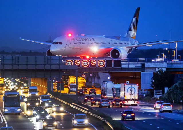 An aircraft crosses a bridge over a highway the airport in Frankfurt, Germany, Friday, September 20, 2019. Protests of the “Friday For Futurte” movement against the increase of carbon dioxide emissions are planned Friday in cities around the globe. In the United States more than 800 events were planned Friday, while in Germany more than 400 rallies are expected. (Photo by Michael Probst/AP Photo)