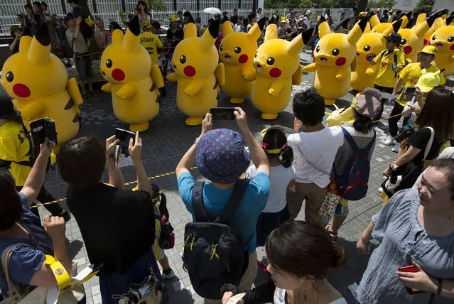 Performers dressed as Pikachu, a character from Pokemon series game titles, march during the Pikachu Outbreak event hosted by The Pokemon Co. on August 9, 2017 in Yokohama, Kanagawa, Japan. (Photo by Tomohiro Ohsumi/Getty Images)