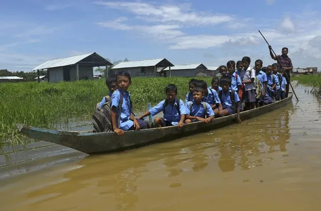 Flood-affected children use a boat to reach their school after incessant rains at Jorhat district in Assam, India, August 22, 2015. (Photo by Reuters/Stringer)