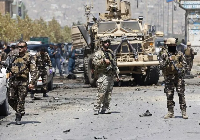 NATO troops arrive at the site of a suicide car bomb attack in Kabul August 10, 2014. A suicide car bomber targeted a convoy of foreign forces in the capital Kabul on Sunday, killing at least four Afghan civilians, including children, and wounding dozens, Afghan security officials said. (Photo by Omar Sobhani/Reuters)