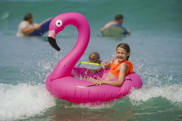 A young girl rides her inflatable pelican in the sea at Fistral Beach on July 18, 2022 in Newquay, Cornwall, England. Temperatures were expected to hit 40C in parts of the UK this week, prompting the Met Office to issue its first red extreme heat warning in England, from London and the south-east up to York and Manchester. (Photo by Hugh Hastings/Getty Images)