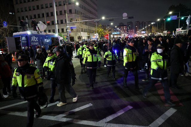Police officers walk among the crowd, after South Korean President Yoon Suk Yeol declared martial law, in Seoul, South Korea, on December 4, 2024. (Photo by Kim Hong-Ji/Reuters)