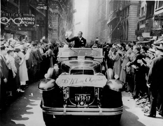 Olympic gold medal winner Jesse Owens waves from an open car during a ticker tape parade along Broadway in New York City on September 3, 1936. The twenty-two-year-old won four gold medals at the Summer Olympics in Berlin, Germany. (Photo by AP Photo)