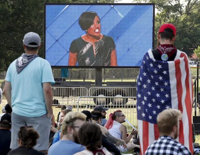 Protesters watch on a large screen from Franklin Delano Roosevelt Park in Philadelphia as Baltimore Mayor Stephanie Rawlings-Blake conducts the roll-call vote, Tuesday, July 26, 2016, during the second day of the Democratic National Convention. (Photo by Alex Brandon/AP Photo)