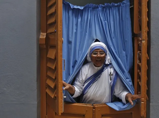 A Catholic nun from the Missionaries of Charity, the global order of nuns founded by Mother Teresa, opens a window after taking part in a mass service to mark Teresa's 18th death anniversary in Kolkata, India, September 5, 2015. Teresa, a Nobel Peace Prize winner who died in 1997, was beatified by Pope John Paul II in 2003 at the Vatican. (Photo by Rupak De Chowdhuri/Reuters)