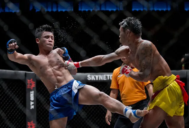 In this Saturday, July 18, 2015, photo, fighters exhibit lethwei –a Myanmar traditional martial art which practices a rough form of kickboxing – at a mixed-martial-arts “One Championship” event broadcast globally on cable television networks, in Yangon, Myanmar. Fighters could receive $1,000 for each fight, according to coach Myint Zaw who runs a street side traditional fighters' club he started 15 years ago. (Photo by Gemunu Amarasinghe/AP Photo)