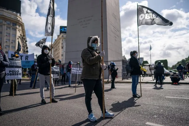 Activists block an avenue next to the Obelisk, behind, during a demonstration demanding food for the soup kitchens that feed the most vulnerable during the mandatory lockdown amid the spread of the new coronavirus pandemic in Buenos Aires, Argentina, Wednesday, May 6, 2020. The pandemic is hitting Argentina during a recession, with soaring inflation and more than a third of its population living in poverty. (Photo by Victor R. Caivano/AP Photo)