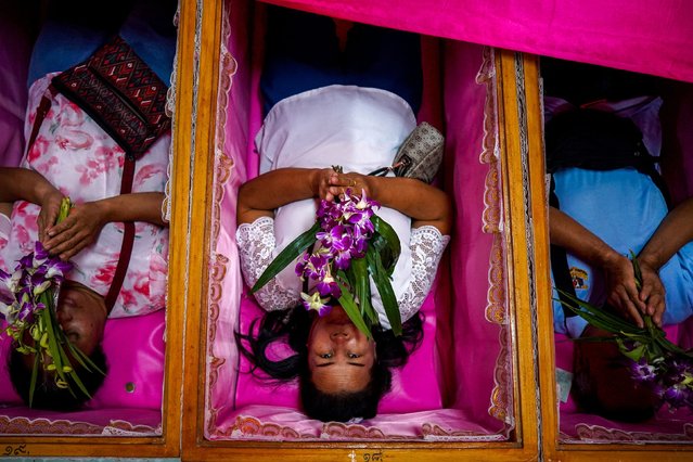 Devotees pray as they lie down inside coffins to get rid of bad luck and to be reborn again for a fresh start in the New Year at a temple in Nonthaburi, on the outskirts of Bangkok, Thailand on January 1, 2025. (Photo by Athit Perawongmetha/Reuters)