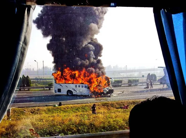 A tourist bus is engulfed in flames on an expressway near Tianjin, China, on Oktober 1, 2012. 5 Germans and a Chinese citizen were killed when the bus burst into flames after hitting the back truck. (Photo by Xinhua)