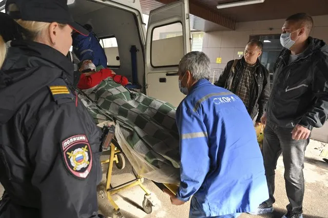 Medical staff carry an injured person into an ambulance at the emergency department of the First Republican Clinical hospital to evacuate to Moscow, in Izhevsk, Russia, Tuesday, September 27, 2022. (Photo by Dmitry Serebryakov/AP Photo)
