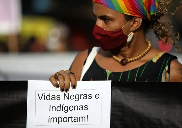 A woman wearing a mask holds a sign during an anti-racism demonstration named “Black and Indigenous Lives Matter” in Manaus, Brazil on June 7, 2020. (Photo by Bruno Kelly/Reuters)