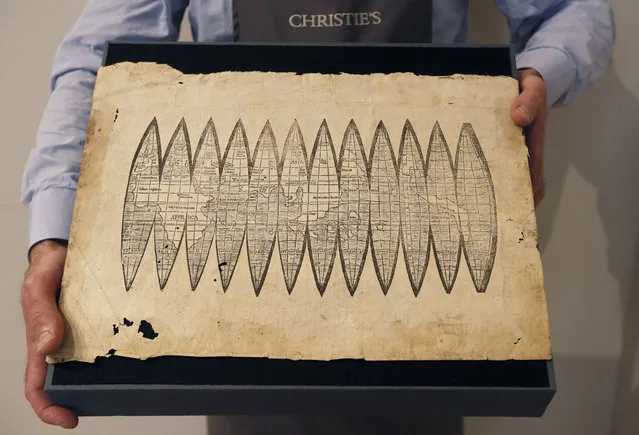 A world map in the form of a set of gores for a terrestrial globe, from 1507 by cartographer Martin Waldseemueller is displayed at Christie's auction rooms in London, Tuesday, November 7, 2017. The map is the first map to name America, and is expected to realise 600,000 -900,000 UK pounds (788,229-1,182,344 US Dollars) when it is auctioned in London on Dec.13. (Photo by Kirsty Wigglesworth/AP Photo)