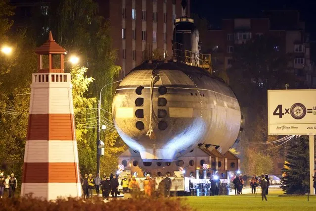 The bow of the Soviet submarine K-3 “Leninsky Komsomol” is transported by a platform along the street from the pier to the museum where it will be assembled with the stern and installed as a museum, in the city of Kronstadt, outside St. Petersburg, Russia, Wednesday, October 12, 2022. K-3 “Leninsky Komsomol” (NATO reporting project name “November”), the first nuclear submarine of the Soviet Union was built in 1957 and based in Soviet Navy's Northern Fleet in Murmansk region. In 1967, while transiting the Norwegian Sea, 39 crew members of K-3 died in bow compartments in the fire. (Photo by Dmitri Lovetsky/AP Photo)