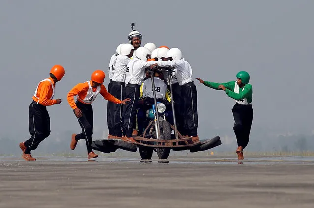 Members of Army Service Corps (ASC) “Tornadoes”, the motorcycle display team of the Indian army, run to climb onto a motorcycle as they attempt to create a world record for most men on a single moving motorcycle at the Yelahanka Air Force Station in Bengaluru, India, November 19, 2017. (Photo by Abhishek N. Chinnappa/Reuters)