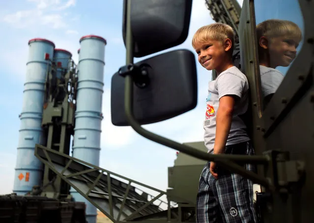 A boy stands on the S-300 air defence mobile missile system during the International Army Games 2016 at the Ashuluk military polygon outside Astrakhan, Russia, August 7, 2016. (Photo by Maxim Shemetov/Reuters)