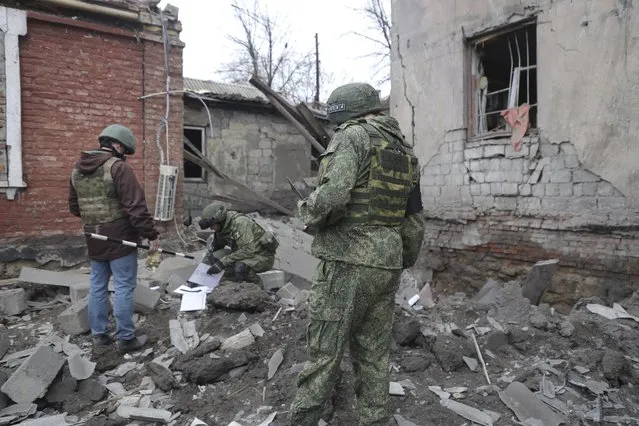 Investigators inspect a site of an apartment building after shelling by Ukrainian forces in Makiivka, Donetsk People's Republic, eastern Ukraine, Friday, November 4, 2022. (Photo by AP Photo/Stringer)