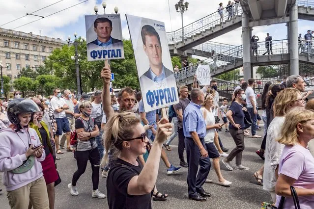 People hold up posters with portraits of Sergei Furgal during an unsanctioned protest in Khabarovsk, 6100 kilometers (3800 miles) east of Moscow, Russia, Saturday, July 11, 2020. Thousands of demonstrators in the Russian Far East city of Khabarovsk held a protest against the arrest of the region's governor on charges of involvement in multiple murders. (Photo by Igor Volkov/AP Photo)
