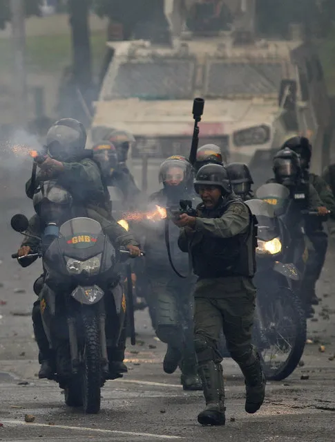 Bolivarian National Guards fire rubber bullets as they advance toward anti-government demonstrators in Caracas, Venezuela, Friday, July 28, 2017, two days before the vote to begin the rewriting of Venezuela's constitution. Protesters say the election of a constitutional assembly will allow President Nicolas Maduro to eliminate democratic checks and balances and install an authoritarian single-party system. (Photo by Ariana Cubillos/AP Photo)